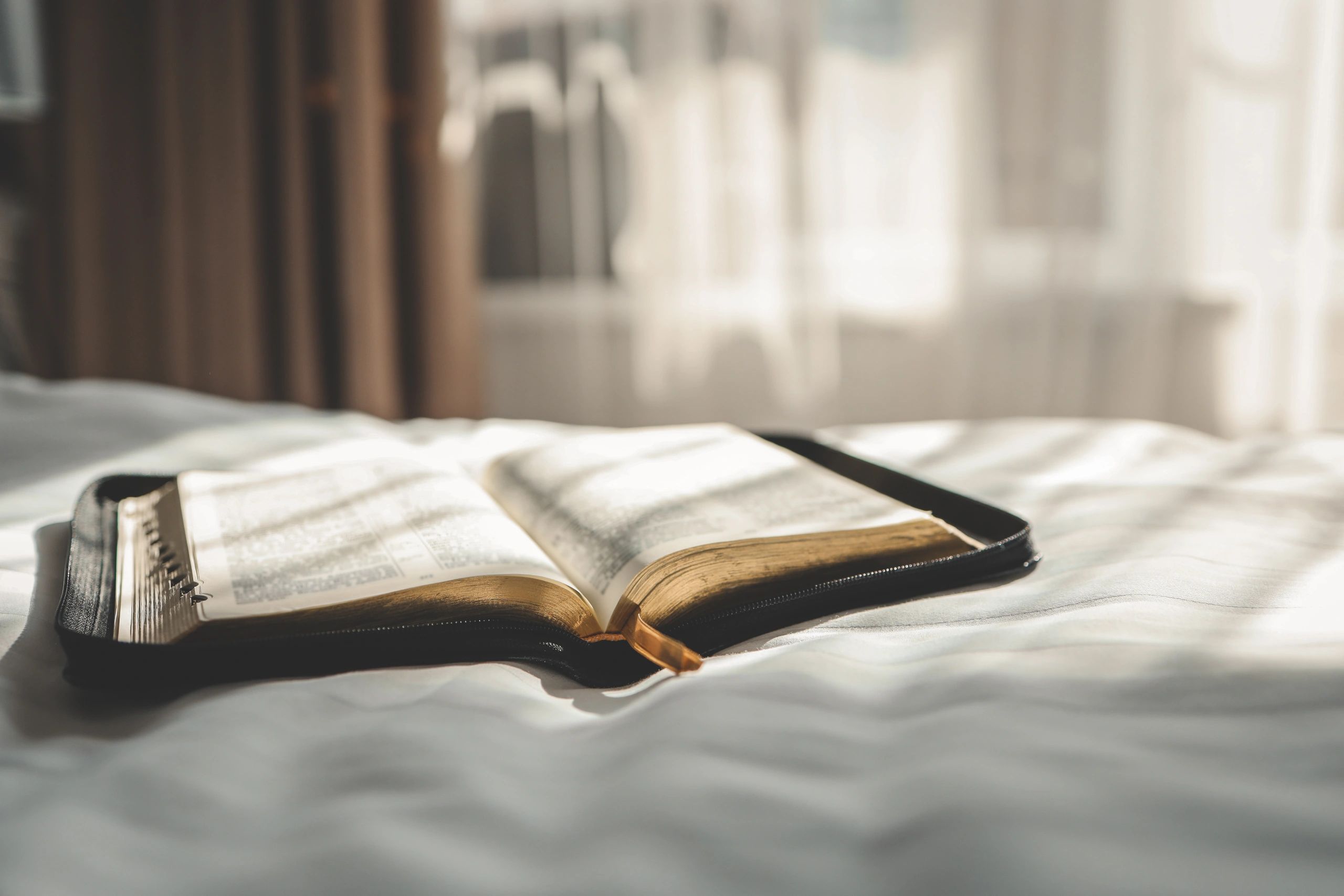 Open Bible on a bed during morning prayer